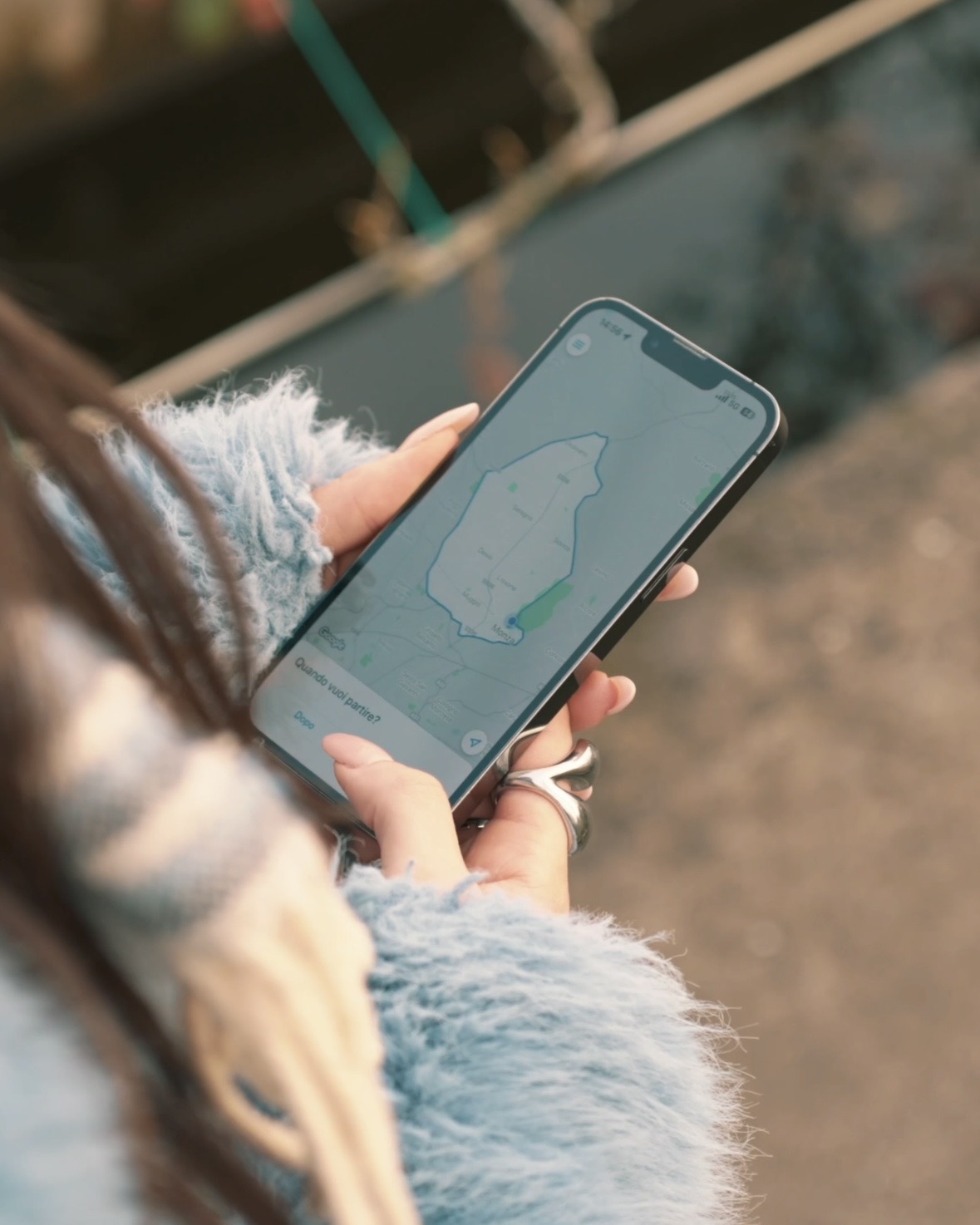 Mani che tengono uno smartphone con una mappa aperta su Monza